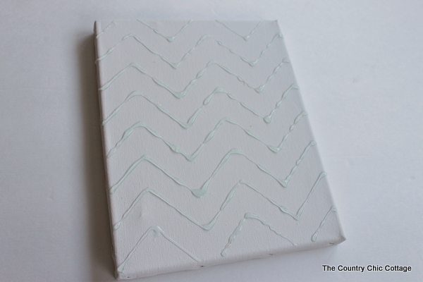 rainy day kids craft canvas art adding glue to a canvas