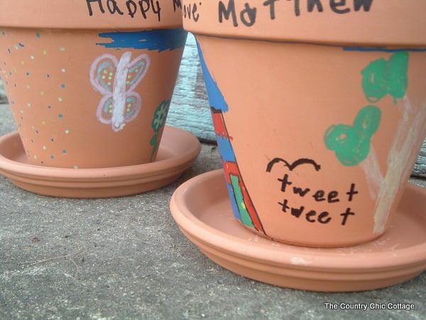 two terra cotta pots painted by children