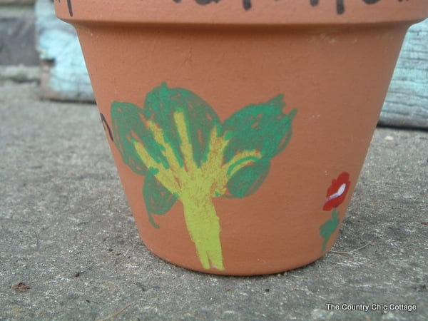 Tree painted on flower pot with yellow tree trunk