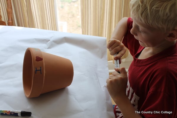 a child painting a terra cotta pot