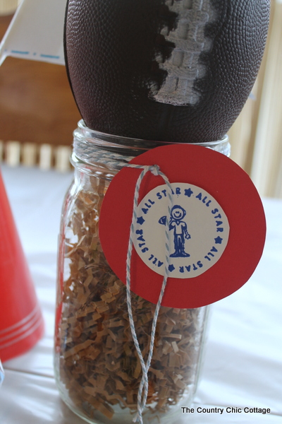 Finished sports-themed birthday party football mason jar centerpiece with all star tag tied on with baker's twine.