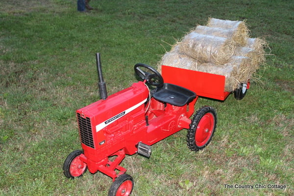 Pedal tractor with homemade hay trailer attached.