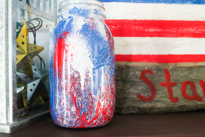 This patriotic mason jar is splattered with red, white, and blue paint