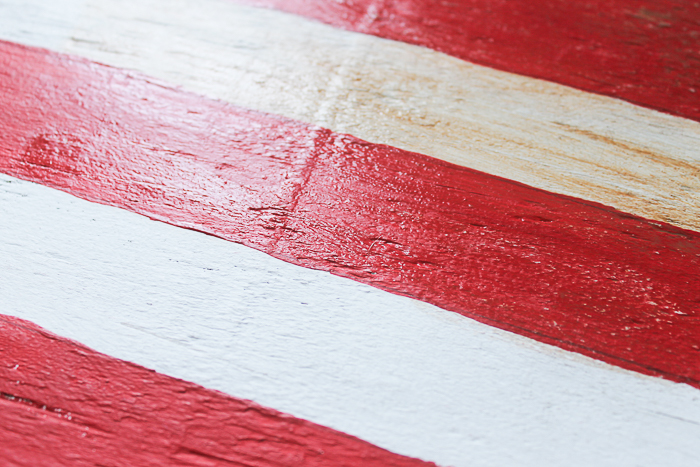 Use the watered down wood stain to distress areas of the painted wooden American flag