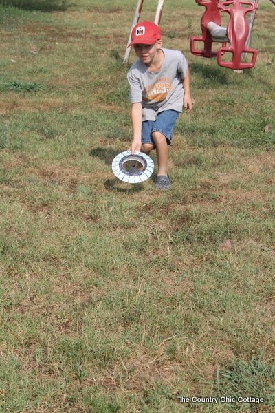 young boy throwing frisbee outside 