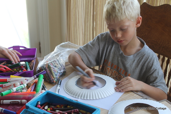 boy coloring paper plate frisbee