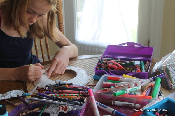 girl coloring paper plate frisbee