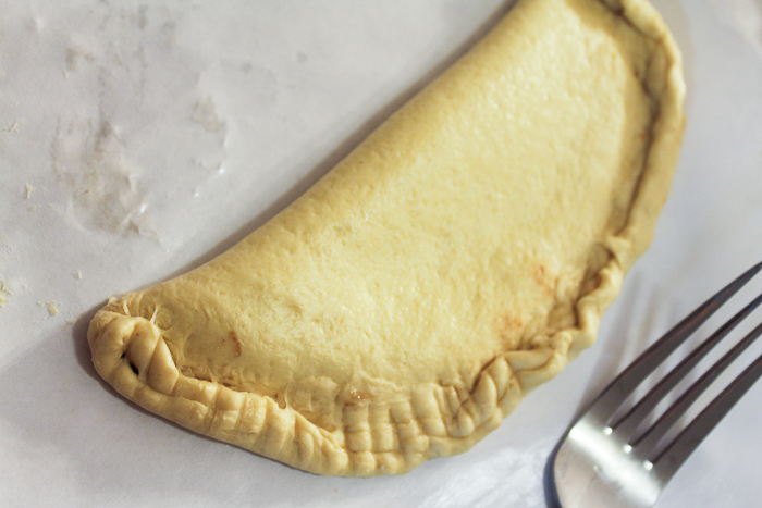 Closing up fried pie dough with Nutella inside.