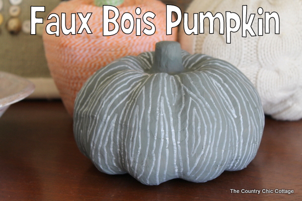faux bois pumpkin in front of two other decorative craft pumpkins