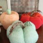 three pumpkins with sweaters