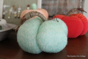 two DIY sweater craft pumpkins in blue and orange