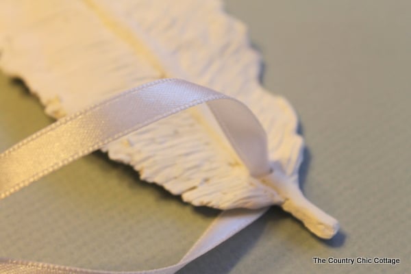 tieing a ribbon in clay feather