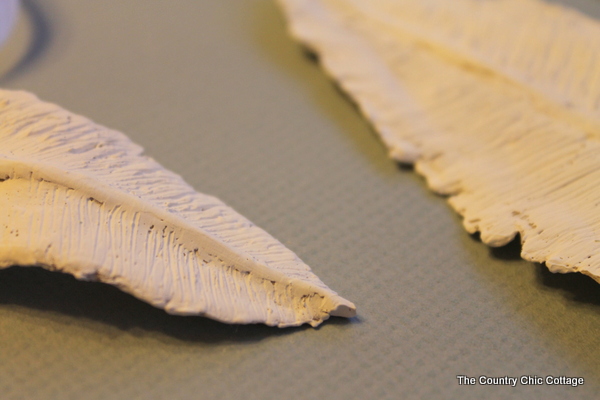white painted clay feathers