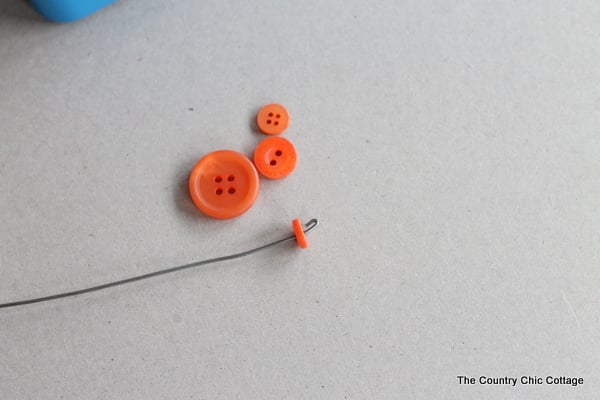 wire with a hook at the end and an orange button on it