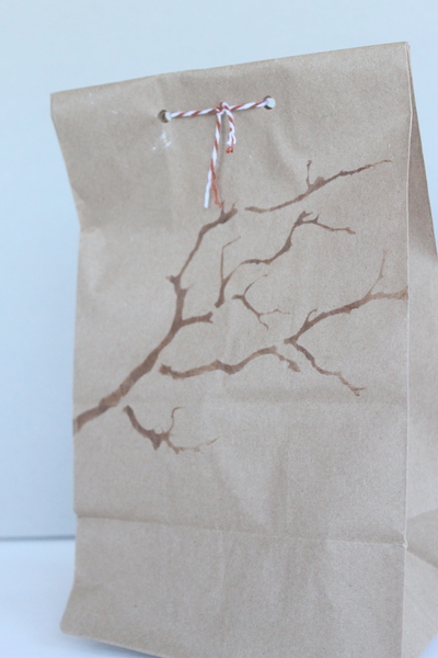 Branch stencil design on brown bag with red and white bakers twine 