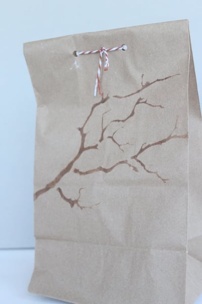 DIY Stenciled Wedding Favor Bags Branch stencil design on brown bag with red and white bakers twine