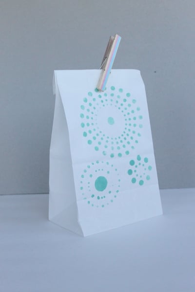White bag with aqua colored stencil and clothespin