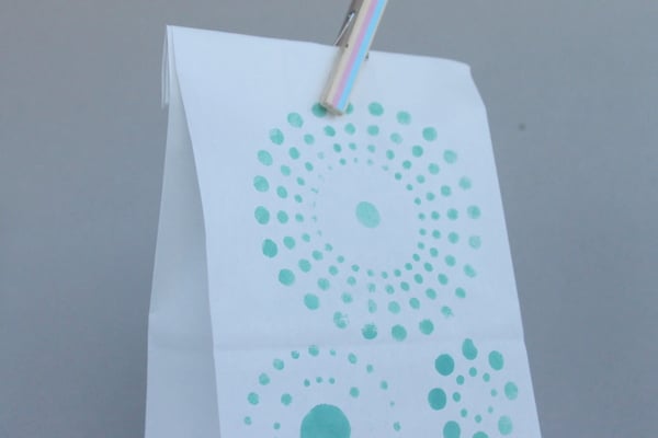 DIY Stenciled Wedding Favor Bags White bag with aqua colored stencil and clothespin