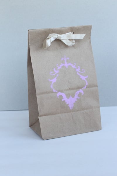 DIY Stenciled Wedding Favor Bags Purple design stenciled on brown bag with white ribbon