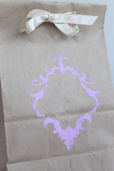 DIY Stenciled Wedding Favor Bags Purple design stenciled on brown bag with white ribbon