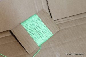 Green yarn wrapped around cardboard