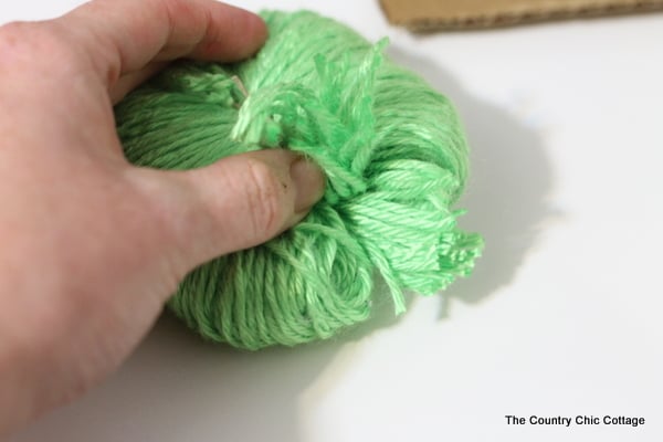 cutting the yarn to make a pom pom