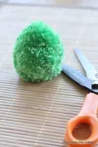 One green pompom with scissors