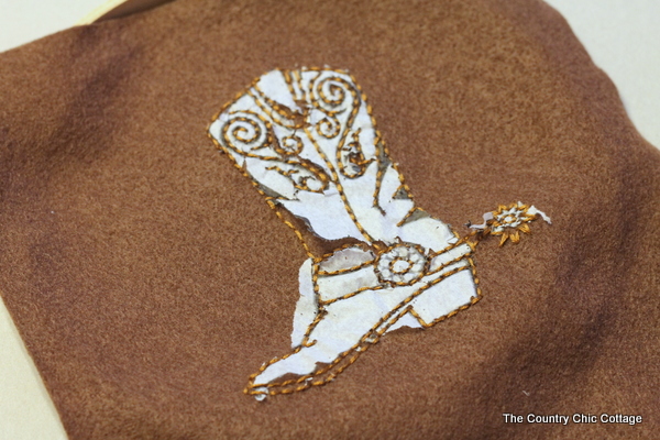 tearing away the tissue paper to leave only the embroidered design