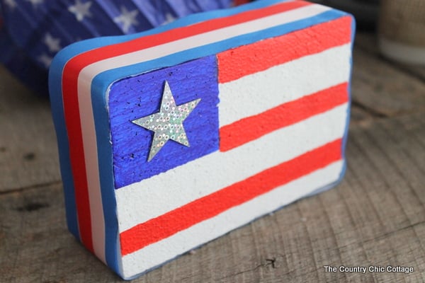 Make an American flag from foam for your patriotic decor this summer. A super simple project that only takes minutes to complete. foam block painted in american flag patterns