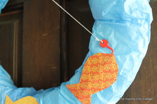 orange paper fish on blue wreath form