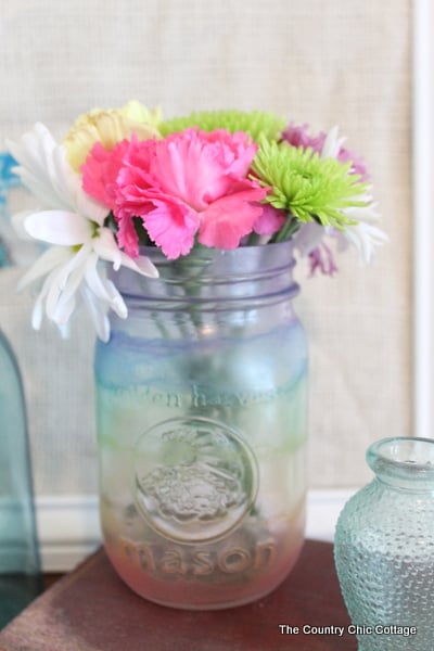 Make frosted glass mason jars in a variety of themes. This patriotic mason jar is just one idea in this post about painting glass mason jars.
