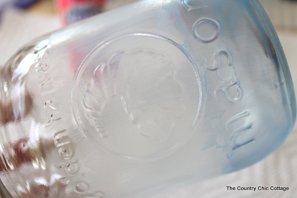 Make frosted glass mason jars in a variety of themes. This patriotic mason jar is just one idea in this post about painting glass mason jars.