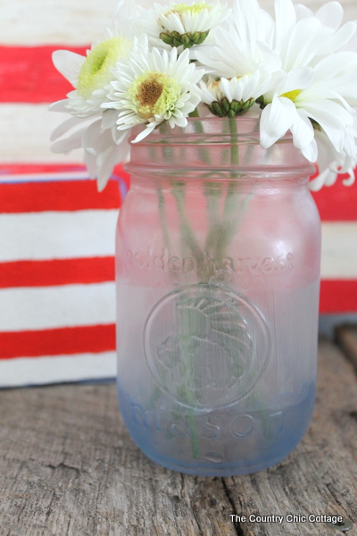 Make frosted glass mason jars in a variety of themes. This patriotic mason jar is just one idea in this post about painting glass mason jars.