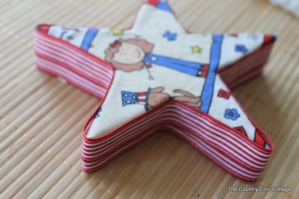 A great buttons and stars garland for your summer or 4th of July decor. Come see how to make this craft with Styrofoam, fabric, and buttons. wrapping the edge of the star for the star garland with ribbon