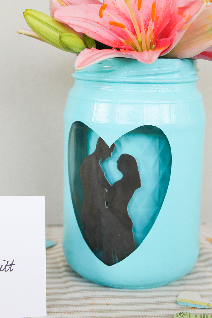 Mason jar centerpieces with flowers using a Cricut machine.