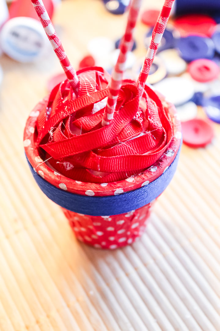 adding ribbon to the top of a clay pot