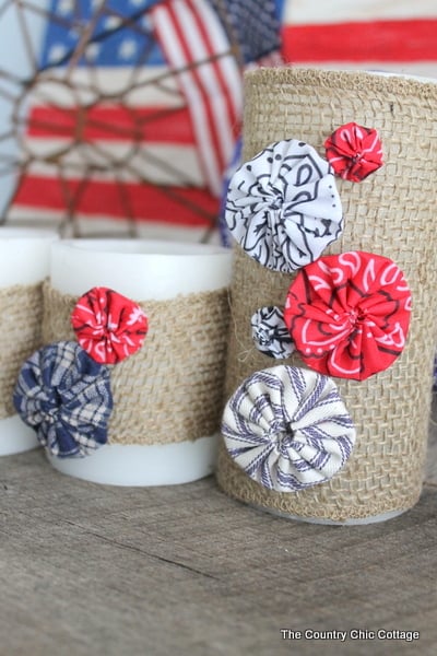 Burlap Yoyo Candle Wraps -- perfect for 4th of July, summer, or change up the colors for any season. Click to get a full tutorial on how to make these great home decor accessories. burlap wrapped candles with fabric yoyos