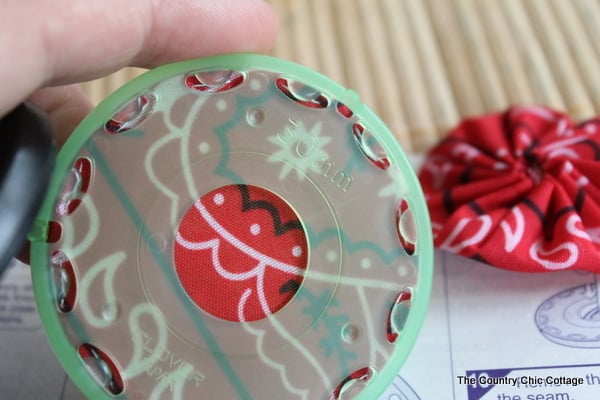Burlap Yoyo Candle Wraps -- perfect for 4th of July, summer, or change up the colors for any season. Click to get a full tutorial on how to make these great home decor accessories. fabric yoyo maker