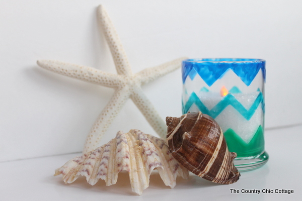 Chevron Beach Themed Candle Holders -- use glass paints to create these great candle holders in minutes. Bring a bit of the beach indoors this summer and add a nautical flair to your decor. Plus there is also a $200 giveaway to enter in this post! Finished candle with sea shells.