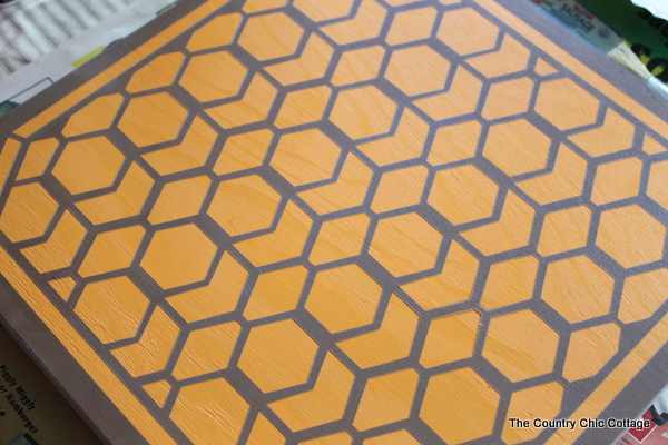 DIY Color Block Mirror -- make this mirrored art for any room in your home easily with a few simple steps. Click to see where to buy the boards, mirrors, paint and stencils to make this great mirror! closeup of stencil on on wood square