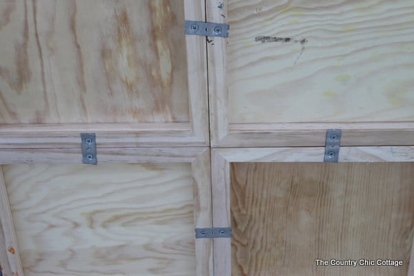 DIY Color Block Mirror -- make this mirrored art for any room in your home easily with a few simple steps. Click to see where to buy the boards, mirrors, paint and stencils to make this great mirror! closeup of metal brackets holding wood squares together