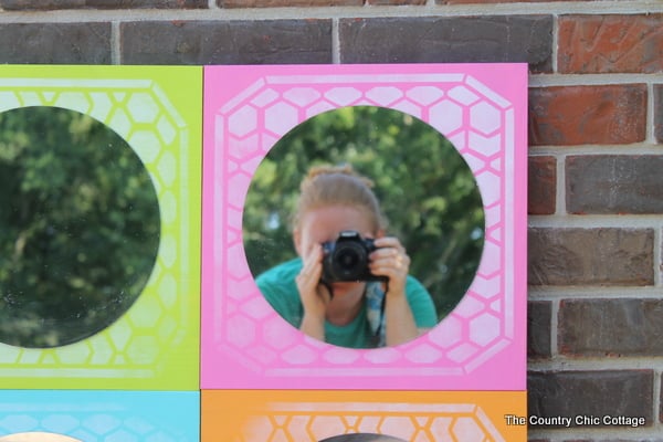 DIY Color Block Mirror -- make this mirrored art for any room in your home easily with a few simple steps. Click to see where to buy the boards, mirrors, paint and stencils to make this great mirror! completed mirror with reflection from taking a picture