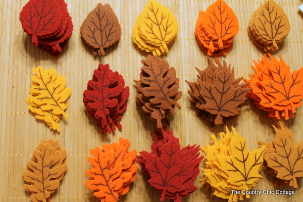 Fall Felt Leaf Garland -- add this to your fall decor. Super simple to make with pre-cut felt leaves and some thread. Come get the full instructions. fall felt leaves in piles