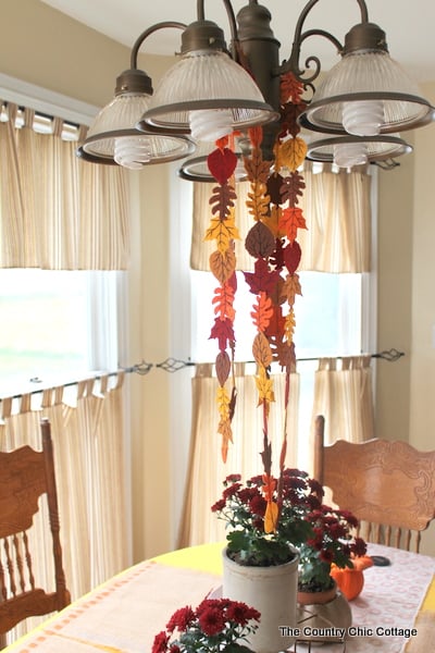 Fall Felt Leaf Garland -- add this to your fall decor. Super simple to make with pre-cut felt leaves and some thread. Come get the full instructions. finished fall felt leaf garland hanging front kitchen light