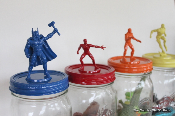 Make great super hero jar toy storage in minutes with this super simple tutorial. Plus learn all about the new Super Buddies movie from Disney. superhero figures on top of jars