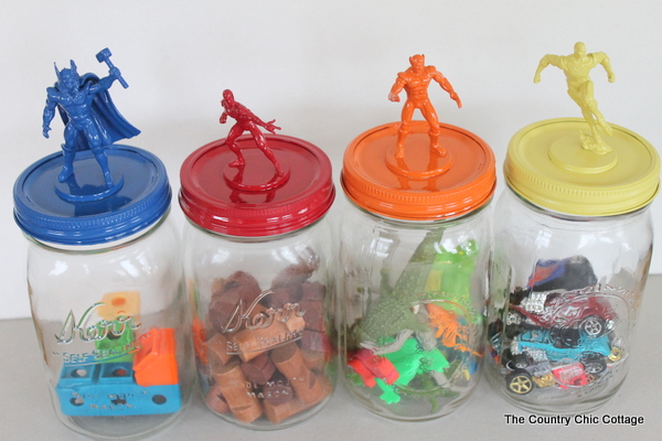 four different colored jars with toy tops