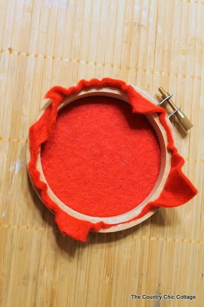 Handmade Gift Idea: 8 hoop ornaments that can be given as gifts this year. Ideas for everyone on your Christmas list. Adding red felt to an embroidery hoop