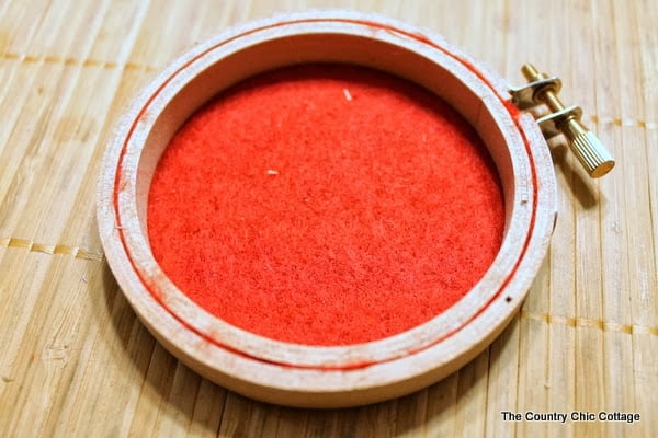 An embroidery hoop on top of red felt 