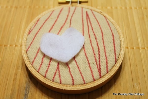 Handmade Gift Idea: 8 hoop ornaments that can be given as gifts this year. Ideas for everyone on your Christmas list. A completed hoop ornament with a heart on top