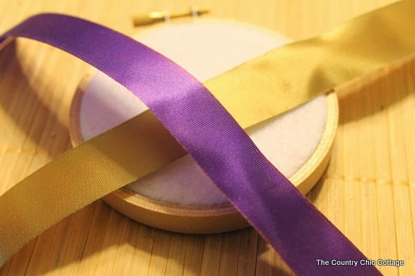 Handmade Gift Idea: 8 hoop ornaments that can be given as gifts this year. Ideas for everyone on your Christmas list. 2 pieces of ribbon laying on a hoop ornament